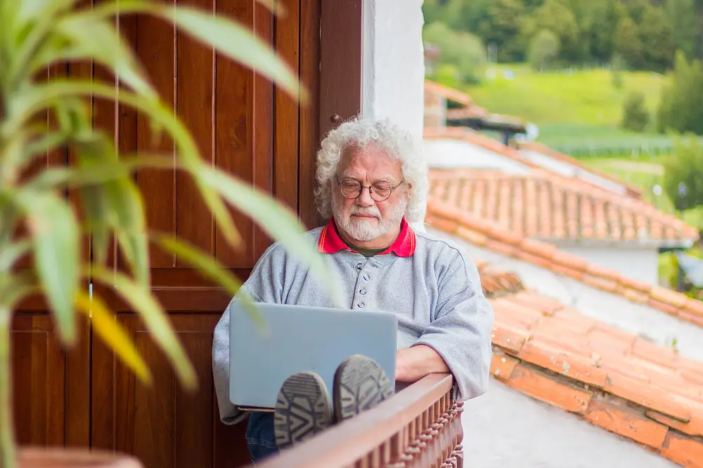 Old male programmer with glasses at his backyard